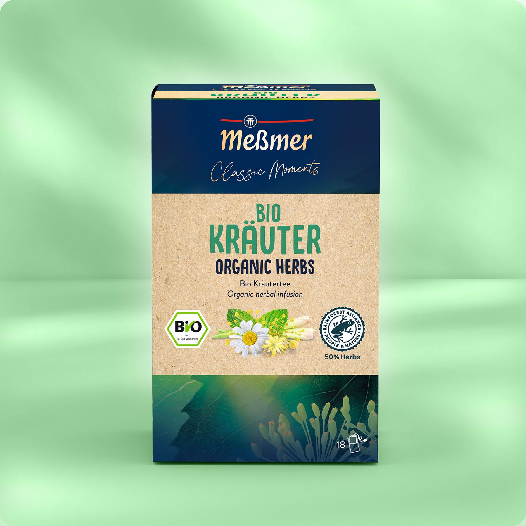 Die Schachtel Meßmer DE Bio Kräutertee zeigt auf der Verpackung Kamillenblüten und grüne Blätter, hebt die Bio-Zertifizierung hervor und enthält 18 Teebeutel. Der Hintergrund ist in einem hellen Grünton gehalten.