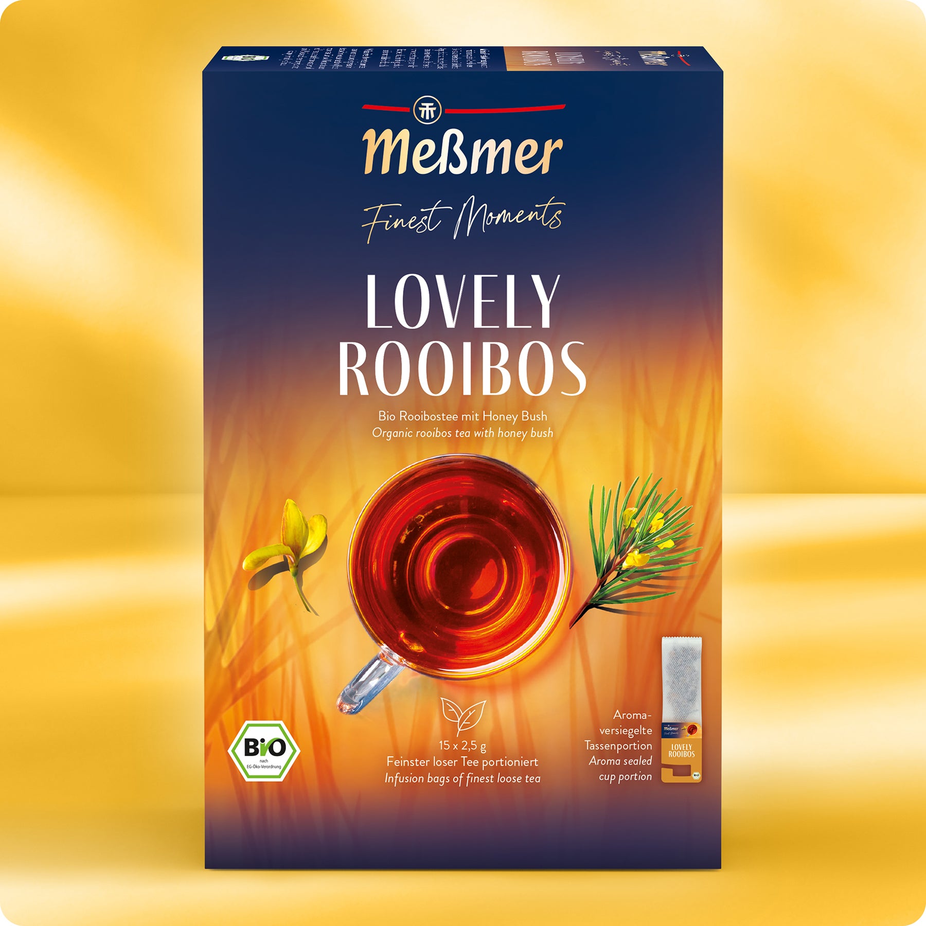 Eine Schachtel Meßmer DE Bio Lovely Rooibos-Tee, mit einer Draufsicht von rotem Tee in einer Glastasse, gelben und grünen botanischen Illustrationen und Produktangaben auf einem orangefarbenen und blauen Hintergrund.