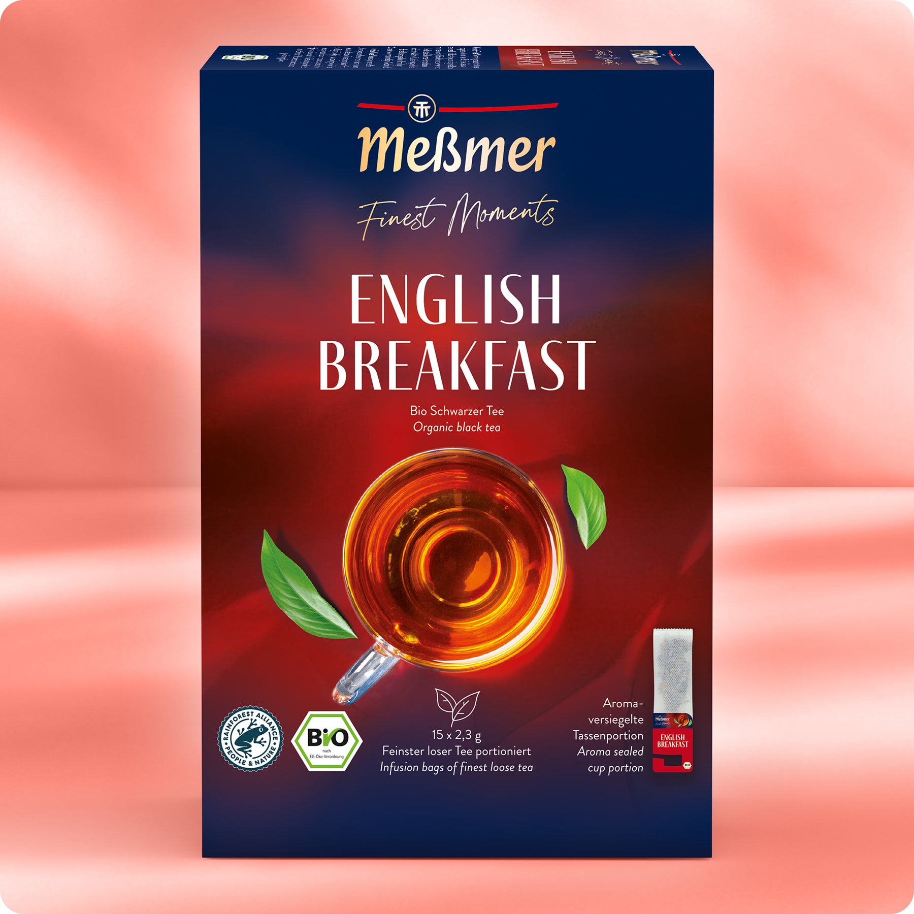 Eine Schachtel Meßmer DE Bio English Breakfast Bio-Schwarztee in roter Verpackung mit Teetasse, Teeblatt und Etiketten für 15 Teebeutel, Bio-Zertifizierung und aromaversiegelter Frische.