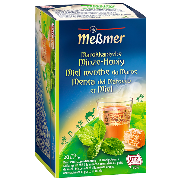 Verpackung des Produkts Marokkanische Minze-Honig von Meßmer mit frischen Minzblättern, Honigwabe und einer Tasse aromatischen Minztees.