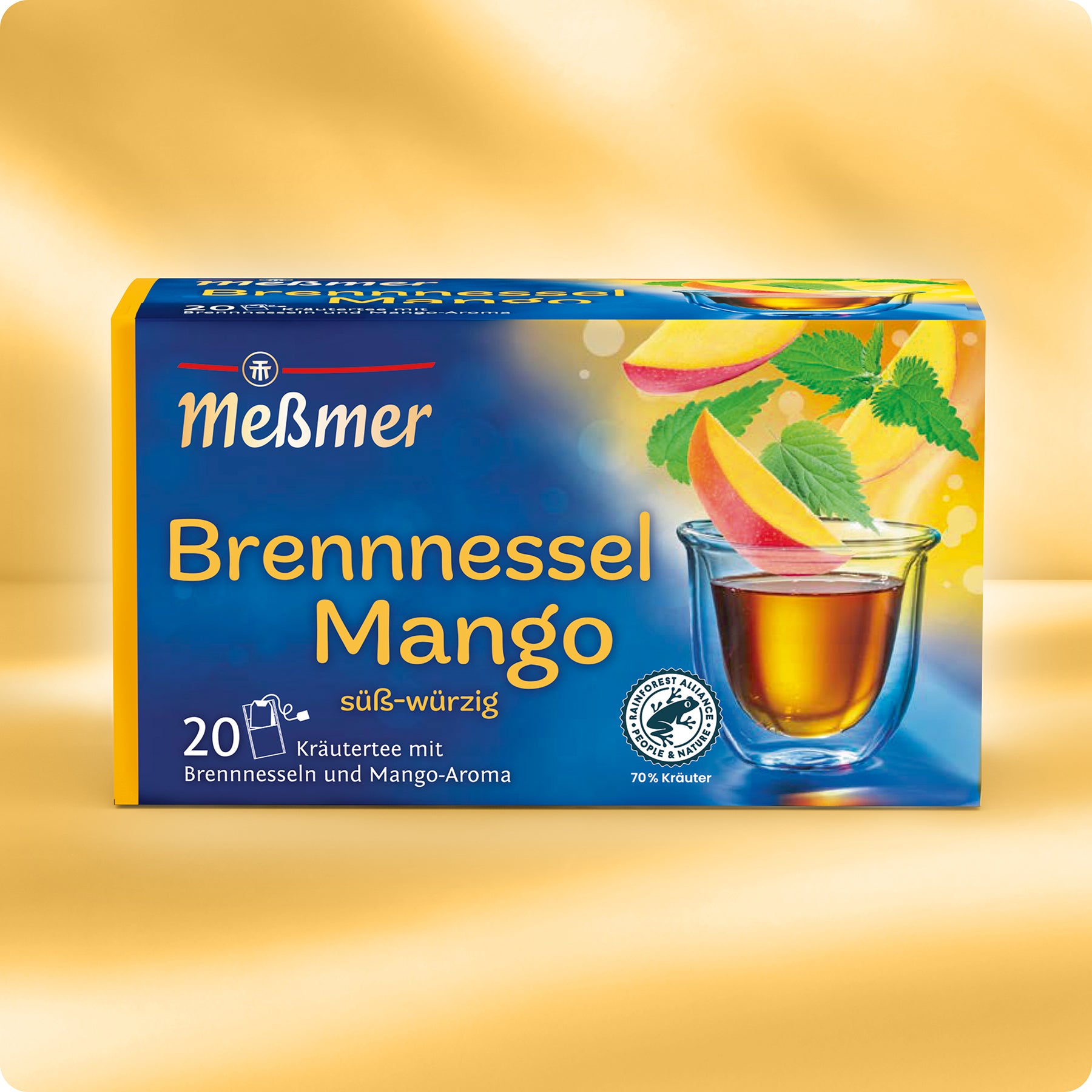 Eine Schachtel Meßmer DE Brennnessel-Mango-Tee mit 20 Teebeuteln, die eine Glastasse mit bernsteinfarbenem Tee, Mangoscheiben und Brennnesselblättern auf einer leuchtend gelben und blauen Verpackung zeigt.