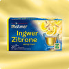 Verpackung von Ingwer-Zitrone Kräutertee mit Darstellung einer Teetasse, die goldgelben Aufguss zeigt, umgeben von frischen Ingwerstücken und Zitronenscheiben, Hinweis auf würzig-frisches Aroma und Care-for-Tea-Siegel.