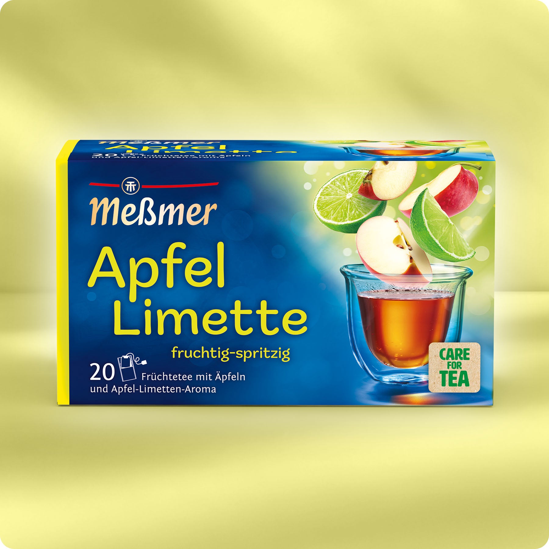 Meßmer Apfel-Limette Früchtetee Verpackung mit Bildern von Äpfeln, Limetten und einer Tasse Tee auf gelbem Hintergrund, fruchtig-spritziger Geschmack.