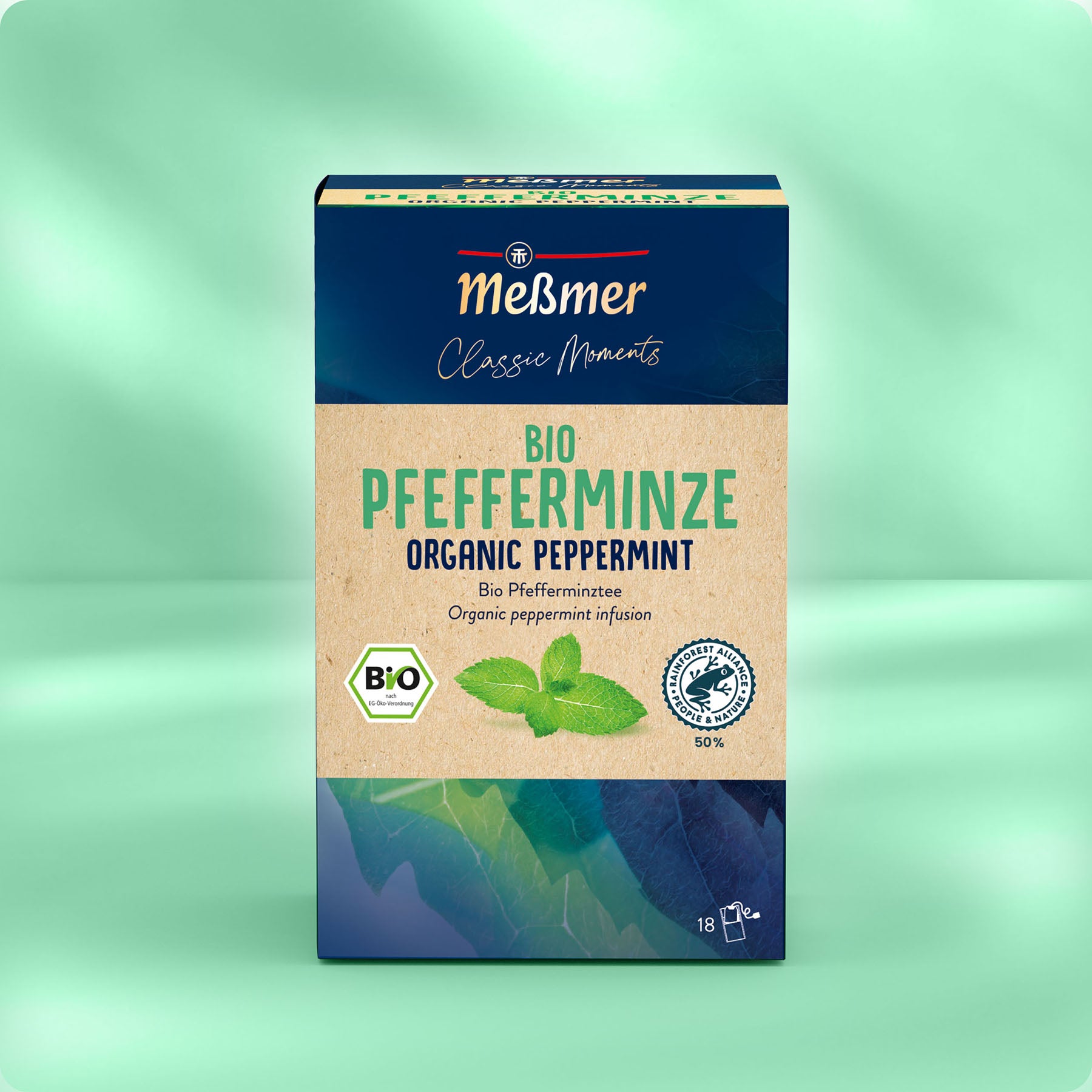 Eine Schachtel Meßmer DE Bio Pfefferminze Tee in grüner und blauer Verpackung mit Minzblatt-Illustration und zweisprachiger Beschriftung ist auf einem zartgrünen Hintergrund abgebildet und bietet intensiven Geschmack in jeder Tasse.