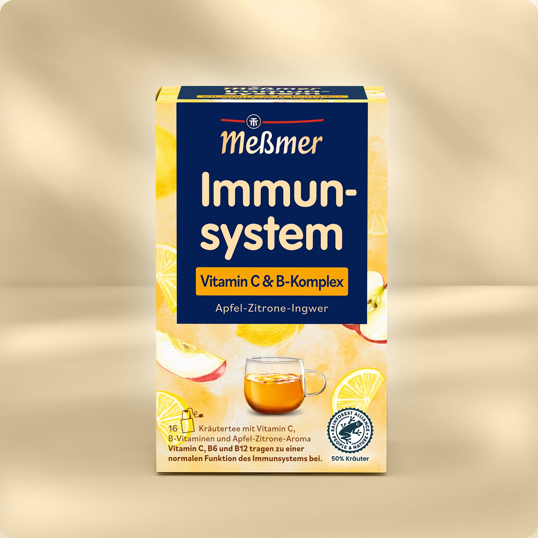 Eine Schachtel Meßmer DE Immunsystem Tee mit Vitamin C- und B-Komplex, eine Mischung aus Apfel-, Zitronen- und Ingwergeschmack. Die leuchtend gelbe Verpackung zeigt eine Teetasse, Zitronenscheiben und Apfelstücke.